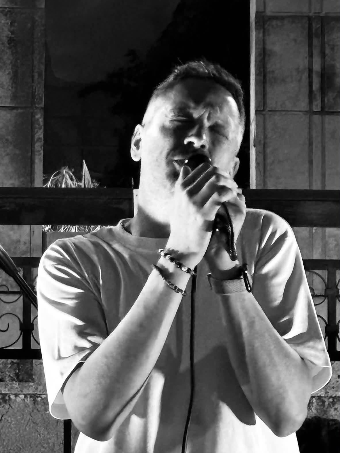 Armando Cacciato al microfono, in un primo piano in bianco e nero durante un live.