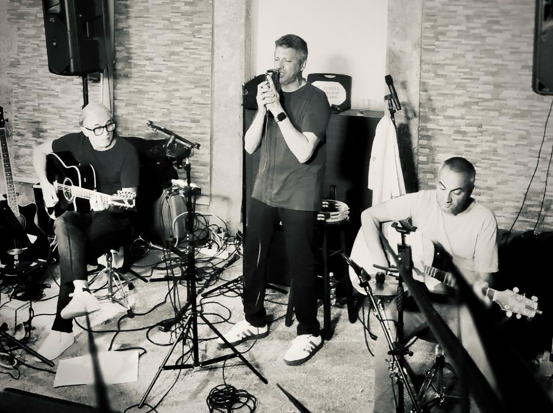 Il trio in un live raccolto: Armando al centro e i due musicisti alle chitarre, in bianco e nero.
